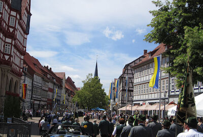 Ein Blick aus dem Auto am Ende des Umzuges heraus auf die Teilnehmer des Umzugs und die geschmückte, von zahlreichem Publikum gesäumte Marktstraße.