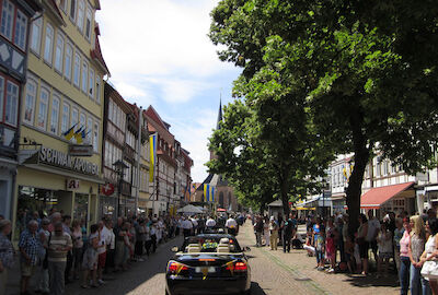 Ein Blick aus dem Auto am Ende des Umzuges heraus auf die Teilnehmer des Umzugs und die geschmückte, von zahlreichem Publikum gesäumte Marktstraße.