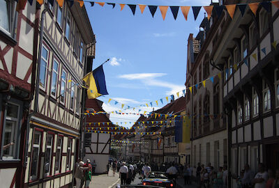 Ein Blick aus dem Auto am Ende des Umzuges heraus auf die Teilnehmer des Umzugs und das geschmückte, von zahlreichem Publikum gesäumte Steintor.